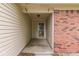 Covered entry featuring brick accents, cream-colored siding, and a glass-paned front door at 6010 Rocky River Dr, Indianapolis, IN 46221