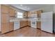 A view of the kitchen with white appliances, wood cabinets, and a large window for natural light at 6010 Rocky River Dr, Indianapolis, IN 46221