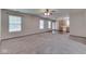 Bright living room with neutral carpet, a ceiling fan, and open access to the kitchen and exterior at 6010 Rocky River Dr, Indianapolis, IN 46221