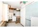 An unfinished laundry room with a washing machine, cabinets, tiled walls, and a door at 6238 E 43Rd St, Indianapolis, IN 46226