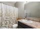Bright bathroom with decorative shower curtain, vanity with a large mirror, and natural light at 6415 Calabash Pl, Indianapolis, IN 46217