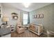 Cozy Bedroom with neutral tones, a white crib, comfortable armchair, and charming animal-themed decor at 6415 Calabash Pl, Indianapolis, IN 46217