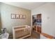 Bright Bedroom featuring a closet, wooden crib with animal decor, and stylish wallpaper at 6415 Calabash Pl, Indianapolis, IN 46217