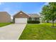 Charming brick home featuring an attached two-car garage and a well-maintained lawn with landscaping at 6415 Calabash Pl, Indianapolis, IN 46217