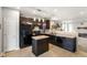 Modern kitchen featuring dark cabinetry, sleek appliances, and an island, open to the living area at 6415 Calabash Pl, Indianapolis, IN 46217