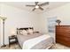 Cozy bedroom with a ceiling fan and a wooden dresser next to a bright window at 6556 Sulgrove Pl, Indianapolis, IN 46221