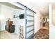 Hallway featuring a sliding barn door, functional storage, and a view into the living area at 6556 Sulgrove Pl, Indianapolis, IN 46221