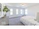Bright bedroom featuring four windows, neutral decor, and gray carpet at 6771 W Buck Stone Dr, McCordsville, IN 46055