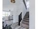 Inviting entryway with hardwood floors, black stair railing, and view to the living room with large windows at 6771 W Buck Stone Dr, McCordsville, IN 46055