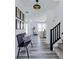 Bright foyer with a bench seat, modern lighting, wood floors, and staircase at 6771 W Buck Stone Dr, McCordsville, IN 46055