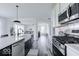 Bright kitchen with white cabinets, modern appliances, and a view into the living room at 6771 W Buck Stone Dr, McCordsville, IN 46055
