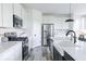 Modern kitchen with stainless steel appliances, white cabinets, and a black kitchen island at 6771 W Buck Stone Dr, McCordsville, IN 46055