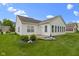 Well-kept backyard with a stone patio, decorative landscaping, and manicured lawn at 7128 Willow Pond Dr, Noblesville, IN 46062