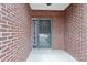 Close-up of the front door, showcasing the brick facade and storm door at 7128 Willow Pond Dr, Noblesville, IN 46062