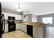 Traditional kitchen featuring white cabinetry, black appliances and open to other rooms at 7128 Willow Pond Dr, Noblesville, IN 46062