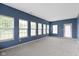 Bright living room with blue walls, multiple windows and neutral carpeting, offering ample natural light at 7128 Willow Pond Dr, Noblesville, IN 46062