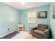 Comfortable bedroom with plush armchair, treadmill, and natural light from the window at 7541 Southern Lakes Dr, Indianapolis, IN 46237