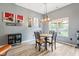 Bright dining room boasts an updated light fixture, modern artwork, and a view of the backyard at 7541 Southern Lakes Dr, Indianapolis, IN 46237