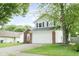 Front exterior of home with attached garage and nice lawn with mature tree at 7541 Southern Lakes Dr, Indianapolis, IN 46237
