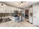 Well-lit kitchen features white cabinets, stainless steel appliances, mosaic backsplash, and plank flooring at 7541 Southern Lakes Dr, Indianapolis, IN 46237