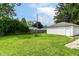 Grassy backyard features a fire pit, a wooden fence, and a detached white garage at 7725 E 52Nd St, Indianapolis, IN 46226