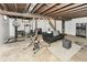 The basement has exposed beams, a small living area, and workout equipment at 7725 E 52Nd St, Indianapolis, IN 46226