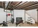 The basement has exposed beams and workout equipment, including a fireplace at 7725 E 52Nd St, Indianapolis, IN 46226