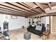 The basement has exposed beams, workout equipment, and a comfortable living area at 7725 E 52Nd St, Indianapolis, IN 46226