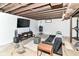 Partially finished basement with exposed ceiling, painted white walls, and a vintage TV set at 7725 E 52Nd St, Indianapolis, IN 46226
