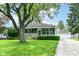 Charming single-story home with a well-maintained lawn, lush landscaping, and detached garage at 7725 E 52Nd St, Indianapolis, IN 46226