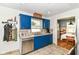 Kitchen featuring blue cabinets, stainless steel dishwasher, and view into dining area at 7725 E 52Nd St, Indianapolis, IN 46226