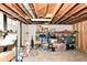 Unfinished basement with exposed beams, concrete floor, shelving, and storage containers at 7725 E 52Nd St, Indianapolis, IN 46226