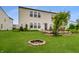 Spacious backyard featuring a fire pit, lush lawn, and a well-maintained two-story home with windows and patio at 8088 Lantern Ln, Pendleton, IN 46064