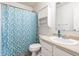 Well-lit bathroom featuring a shower with a blue patterned curtain and a white vanity at 8088 Lantern Ln, Pendleton, IN 46064