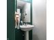 Powder room with pedestal sink, decorative mirror and lighting, and stylish two-tone wall paint for an updated design at 8088 Lantern Ln, Pendleton, IN 46064