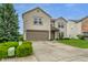 A view of a two-story home with a two-car garage, surrounded by lush green landscaping at 8088 Lantern Ln, Pendleton, IN 46064
