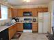 A functional kitchen offering wooden cabinets, an electric range, and a standard refrigerator for your cooking needs at 8165 Amarillo Dr, Indianapolis, IN 46237