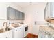 Efficient laundry room with washer, dryer, sink, granite countertop, and overhead cabinets at 8530 Ardennes Dr, Fishers, IN 46038