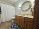 Bathroom with a wooden vanity, oval mirror, and shower-tub combo with a decorative white curtain at 8711 E 296Th St, Atlanta, IN 46031