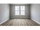 This bedroom features wood-look flooring and a window with white blinds at 9718 Haughton Ln, McCordsville, IN 46055