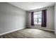 Bedroom showcases wood-look flooring, a large window with blinds and purple curtains at 9718 Haughton Ln, McCordsville, IN 46055