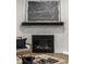 Stylish fireplace with gray tile surround, wooden mantle, and abstract art above at 9718 Haughton Ln, McCordsville, IN 46055