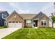 Beautiful brick home featuring a well-manicured lawn, attached garage and inviting curb appeal at 9718 Haughton Ln, McCordsville, IN 46055