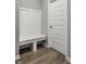 A mudroom bench with hooks near a white door offers organization and style at 9718 Haughton Ln, McCordsville, IN 46055