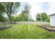 Spacious backyard with a well-maintained lawn, wooden fence and raised garden beds, perfect for outdoor activities at 10244 Washington Blvd, Carmel, IN 46280
