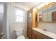 Bathroom features a toilet, sink, cabinet, vanity mirror, and window with natural light at 10244 Washington Blvd, Carmel, IN 46280