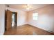 Inviting bedroom with hardwood floors, a window for natural light, and a doorway to another room at 10244 Washington Blvd, Carmel, IN 46280