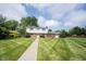 View of front lawn leading to traditional-style home with blue shutters at 10244 Washington Blvd, Carmel, IN 46280