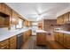 Traditional kitchen boasts wood cabinets, white countertops, island, and brick accent wall with fireplace at 10244 Washington Blvd, Carmel, IN 46280
