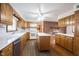 Traditional kitchen boasts wood cabinets, white countertops, island, and brick accent wall with fireplace at 10244 Washington Blvd, Carmel, IN 46280